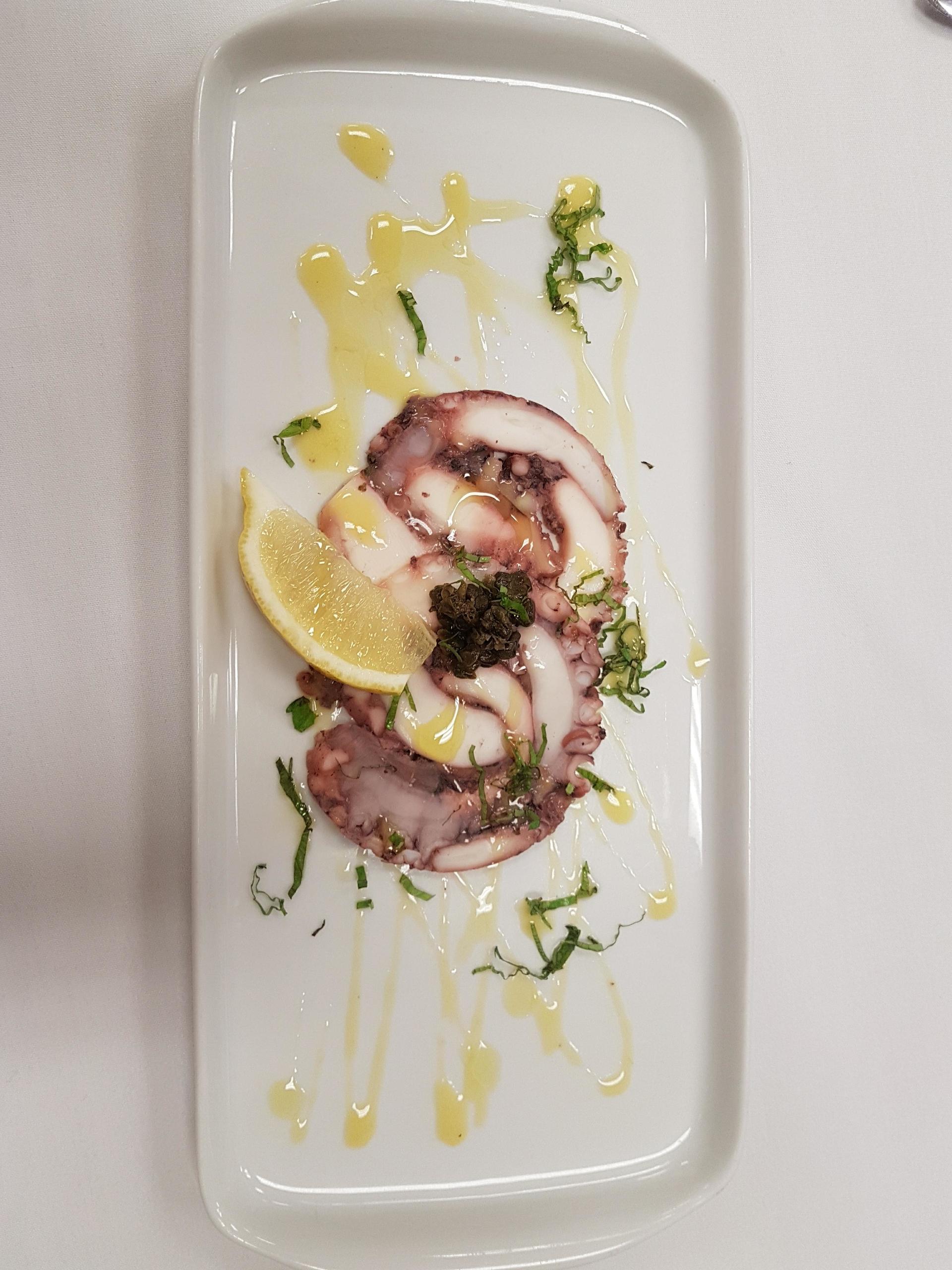 Octopus with lemon slices and herbs